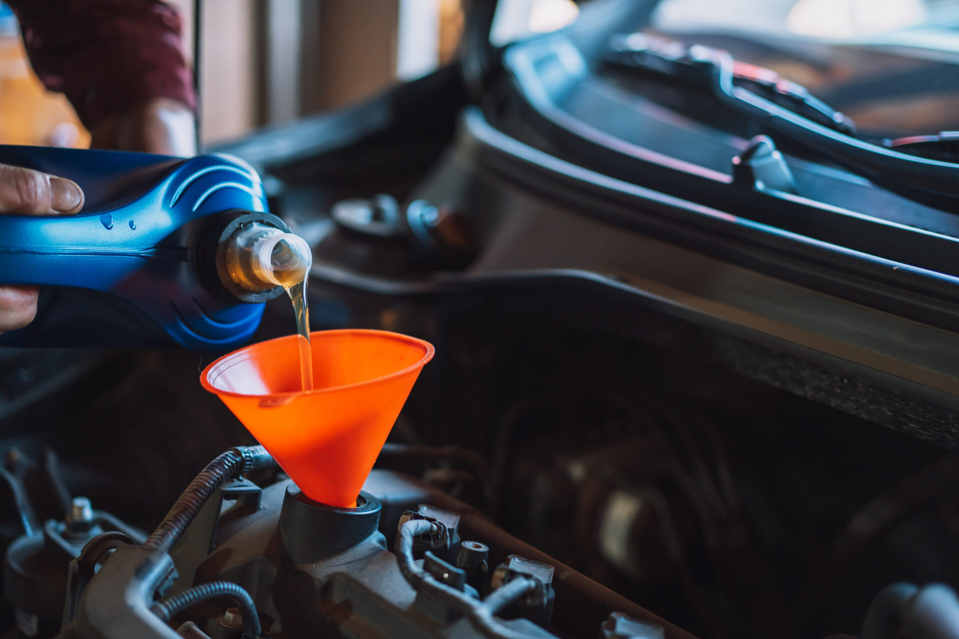The Mechanic Pours New Oil Into The Engine Using Funnel