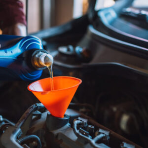 The Mechanic Pours New Oil Into The Engine Using Funnel
